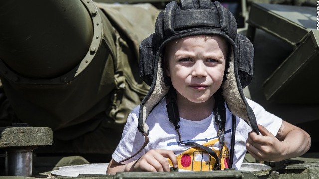 展示された戦車に乗り込む少年