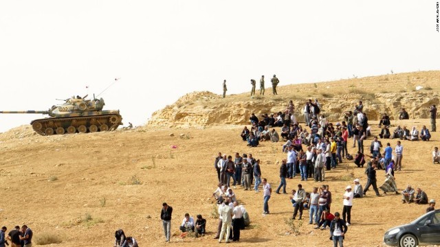シリアでの戦闘の様子をうかがうクルド人部隊とトルコの人々