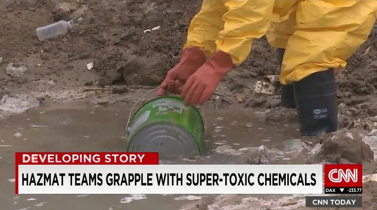 爆発現場付近の水をくみ取る作業者