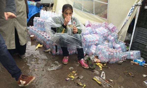 雨の中、ハンガリーとセルビアの国境地域で座り込む難民の子ども