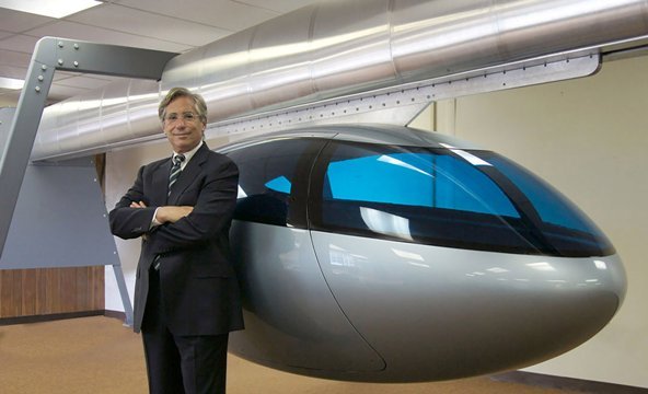 スカイトランのサンダースＣＥＯと、磁気を利用して空中を移動する同社の車両＝SkyTran