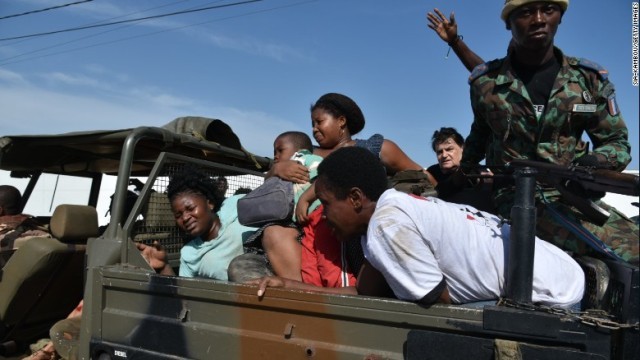 治安部隊の車両で武装集団による襲撃の現場から避難する人々