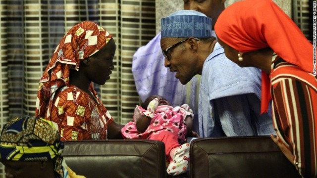 ヌケキさん（左）の産んだ乳児を抱こうとするブハリ大統領＝ナイジェリア大統領府