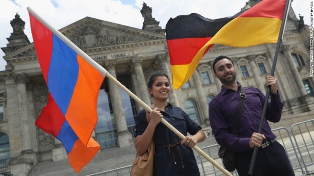 決議の採択後、ドイツとアルメニアの国旗を掲げて議事堂前を歩く人たち