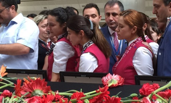 テロの犠牲者に花を捧げる空港職員ら＝Gul Tuysuz