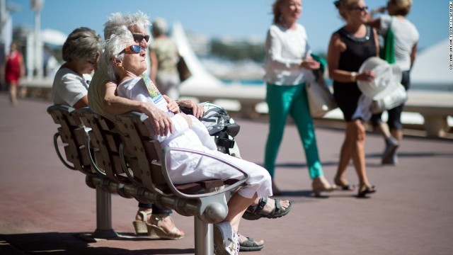 仏カンヌでベンチに腰掛ける高齢者の男女