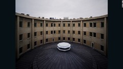 蒼光院のアトリウムの外観。コンクリートを使った円形の建物で、背景には柳京ホテルの一部が見える