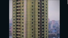 平壌市内のタワーマンション。丸みを帯びた形状の建物は、緑とピンクに塗り分けられている