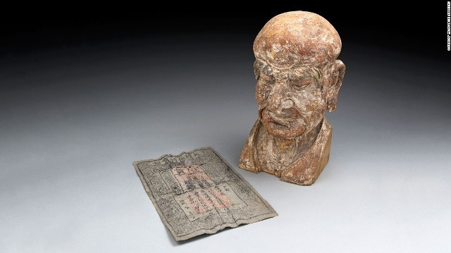 木造の羅漢像の頭部とその中から発見された７００年前の紙幣