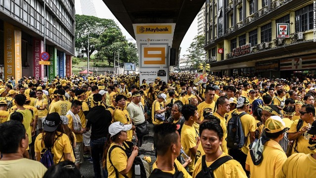 そろいの黄色のシャツを着て通りを埋め尽くすデモの参加者ら