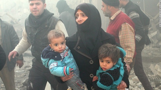 空爆後のアレッポで子どもたちを抱きかかえる女性