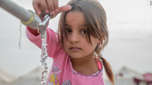 水道の蛇口に手をかけるモスルから来た少女＝イラク・ニネベ州のキャンプ
