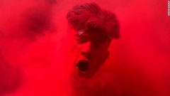 ３月２４日：インドのホーリー祭で踊る男性。顔に赤い粉が塗られている