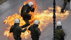 ２月４日：ギリシャ全土でストが行われるなか、首都アテネのストで火炎瓶を避けようとする機動隊員。年金改革をめぐり数万人のデモ参加者と警察が衝突した