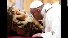 イエスの子どもの人形に口づけをするフランシスコ法王＝バチカン