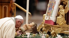 イエスの子どもの像にキスするフランシスコ法王＝バチカン