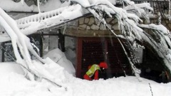 救助隊員がホテル前の雪をかき出す