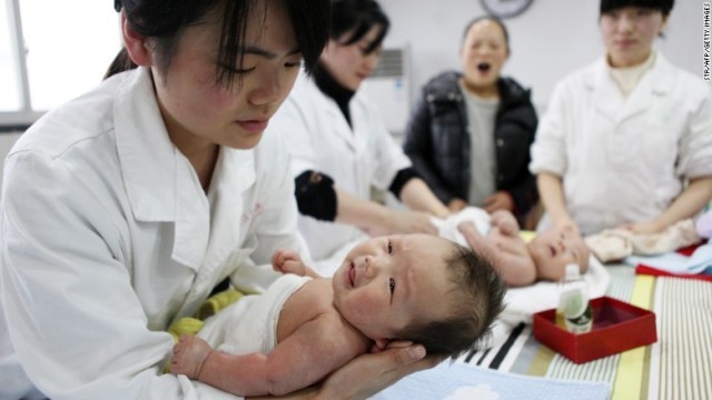 中国の乳児ケアセンターで赤ちゃんを抱く看護師