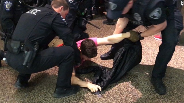 シアトル・タコマ国際空港で警察に拘束されるデモ参加者