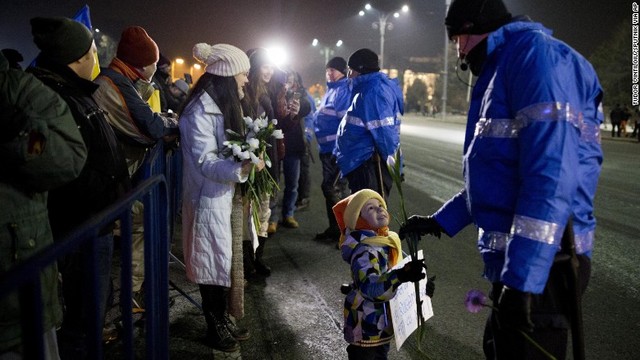 抗議デモの最中、警官に花を差し出す少女＝２月２日