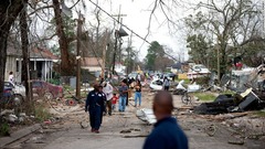 竜巻の直撃後、通りを歩く人々