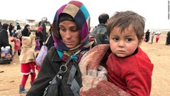 子どもを運ぶ母親。モスルから逃げ出す際に持ち物はほとんど持ち出せなかったという。イラク政府によれば、モスルから逃れてきた人の数は５万人を超える