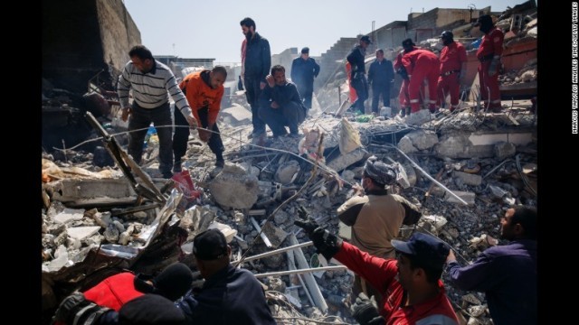 がれきの下から遺体を回収しようとするモスル近郊の住民とイラク民間防衛隊隊員ら