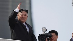 パレードの最中に手を振る金正恩朝鮮労働党委員長
