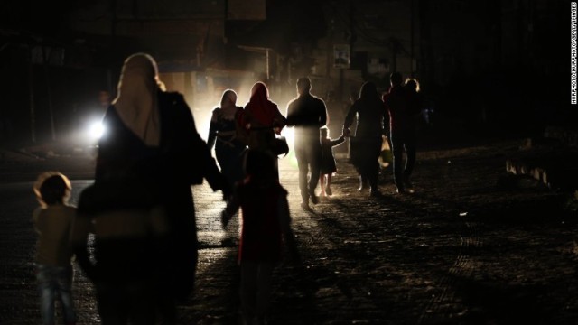 電力不足のため暗闇を歩く人々
