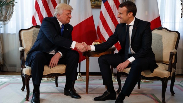 長い握手はマクロン仏大統領（右）との主導権争いか。軍配はどちらに？