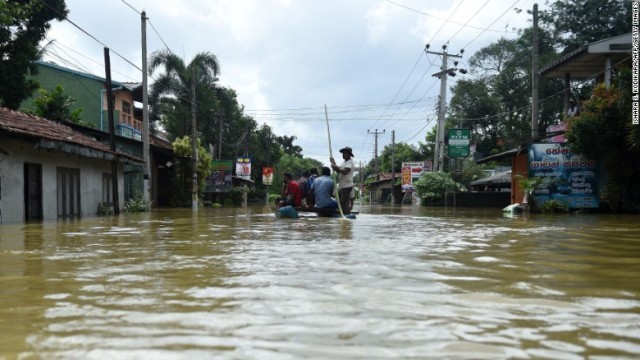 コロンボ郊外の冠水した道路をボートで移動する住民