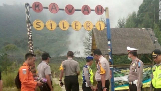 火山に向かうルートの入り口に立つ警官と救急隊員