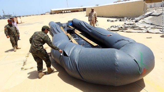 首都トリポリの基地で不法移民が使用したゴムボートに穴を開けるリビア海軍の兵士