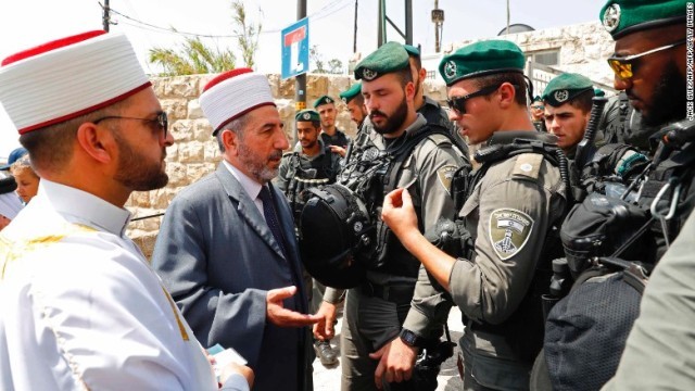 エルサレム旧市街の入り口でイスラエルの兵士と話すイスラム教聖職者