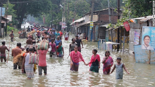 水につかった道路を歩くインド西ベンガル州の人々