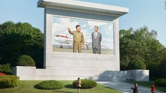 平壌国際空港に立つ北朝鮮の過去の指導者たちの記念碑。背景に２機のロシア製航空機が描かれている