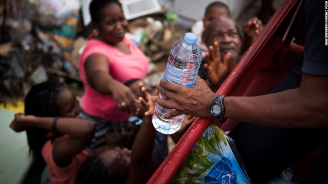 フランスの消防士からペットボトル入りの飲料水を受け取る仏領サンマルタン島の住民
