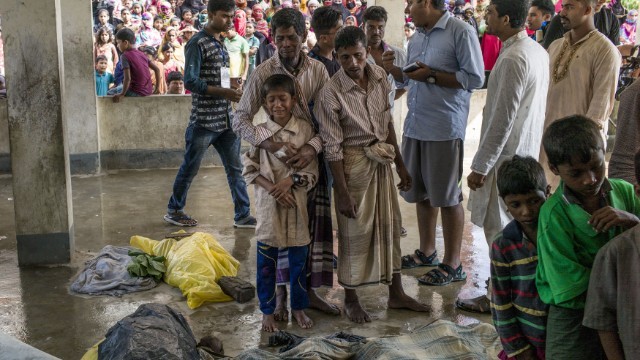 船転覆で死亡した親族の遺体を前に悲しむ人々＝Fred Dufour/AFP/Getty Images