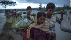 国境を越えた後、水田を歩く女性＝９月９日、バングラデシュ