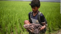 国境の川を渡る際に赤ちゃんを抱える子ども＝９月１２日、バングラデシュ