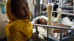 病院で治療中の息子の傍らに立つロヒンギャ難民＝９月１３日、バングラデシュ・コックスバザール