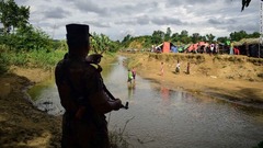 バングラデシュの国境警備員が、水路のミャンマー側に戻るようロヒンギャに命令している＝８月２９日