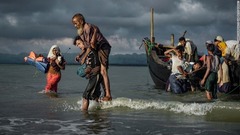 国境の川のバングラデシュ側でボートから降りるロヒンギャ難民＝９月１３日