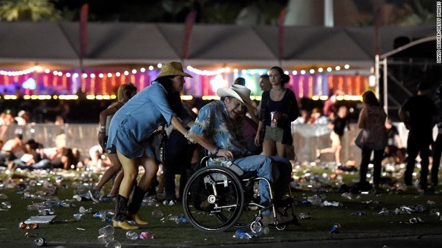 銃声が聞こえた後、音楽祭の会場から運び出される車いすの男性