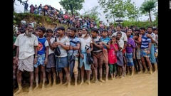 援助機関により配給された食料を受け取るため、ロヒンギャの男性が難民キャンプで列に並んでいる＝９月１９日、バングラデシュ