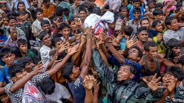 難民キャンプで支援機関により配給された食料を必死に入手しようとする人々＝９月１８日、バングラデシュ
