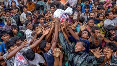 難民キャンプで支援機関により配給された食料を必死に入手しようとする人々＝９月１８日、バングラデシュ<br />
