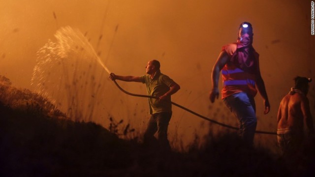 ポルトガルの火災現場で消火活動に当たるボランティアの人々