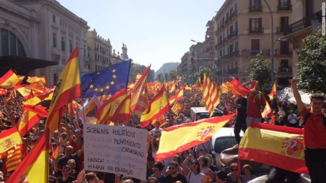 スペインやカタルーニャ、ＥＵの旗を振って団結を呼びかける人々＝１０月８日、バルセロナ