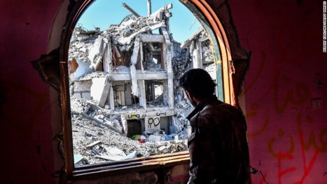 激しく損壊した建物を眺めるシリア民主軍（ＳＤＦ）の兵士